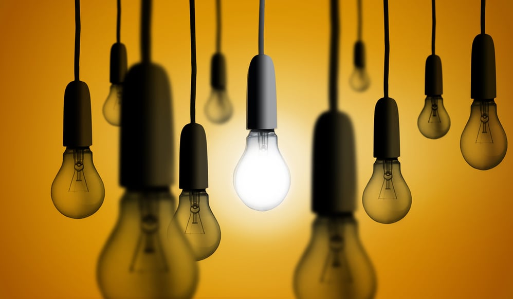 Light bulb glowing against orange background