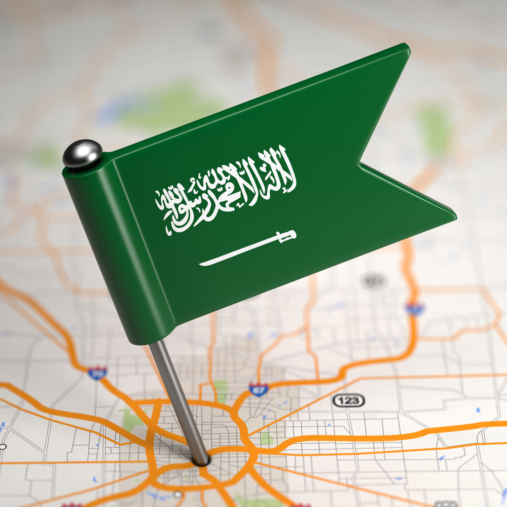 Small Flag of Saudi Arabia on a Map Background with Selective Focus.